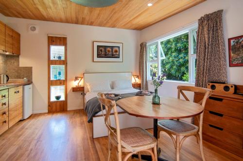 a kitchen and dining room with a table and a bed at Chalet Karaka in Takaka