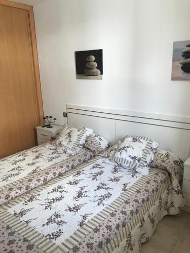 Una cama con edredón en un dormitorio en Apartamento “El Callao”, en Puerto del Rosario