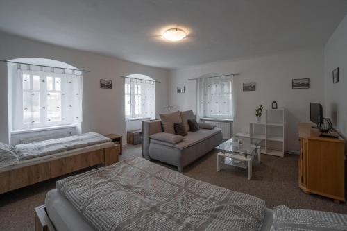a living room with a bed and a couch at Apartmá u Baštů in Česká Kamenice