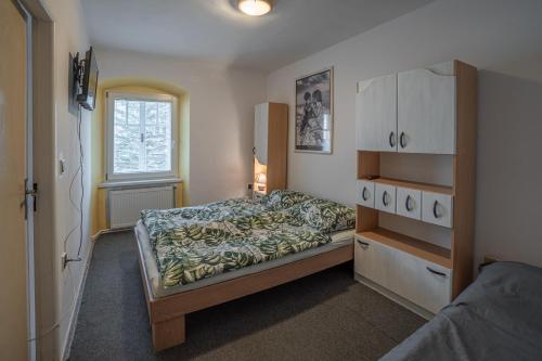 a small bedroom with a bed and a window at Apartmá u Baštů in Česká Kamenice