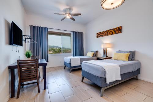 a bedroom with a bed and a desk and a television at Uncle Tonys Hale in Wailuku