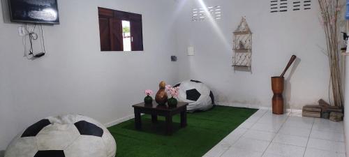 a room with two soccer balls and a table with flowers at Pousada Paraiso dos Galos in Galinhos