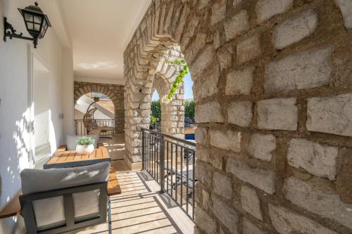 a patio with a stone wall and a table and chairs at Noa Suite Hotel Only Adult in Bodrum City