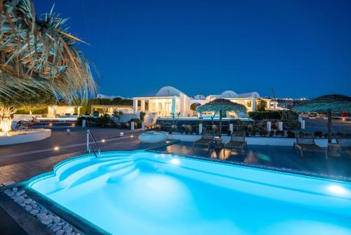 a pool at night with a resort at Oia Sunset Villas in Oia