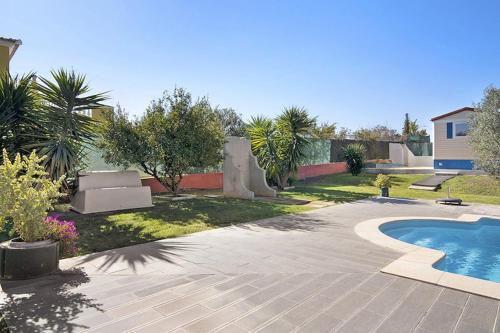a backyard with a swimming pool and a house at Mobile Home 2 - Olhão in Olhão
