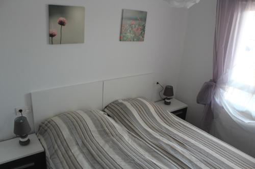een bed met een gestreepte deken in een slaapkamer bij New apartment with sea view of Andrew and Natallia in Campoamor