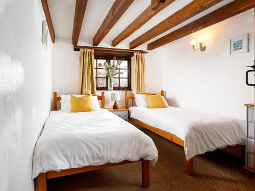 um quarto com 2 camas e uma janela em Little Leighs em Launceston