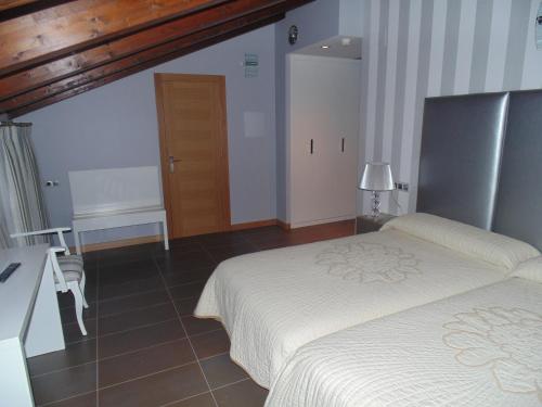 a bedroom with a bed and a table and a desk at Hotel Ribera de Langa in Langa de Duero