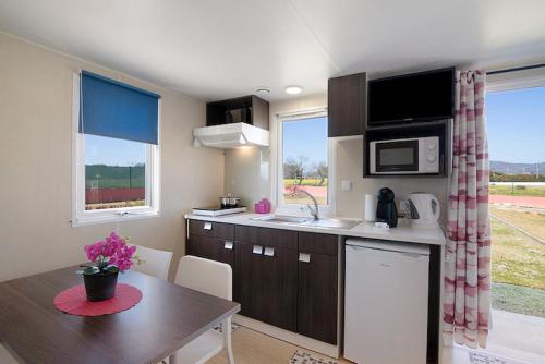 a kitchen with a table and a counter top at Mobile Home 2 - Olhão in Olhão