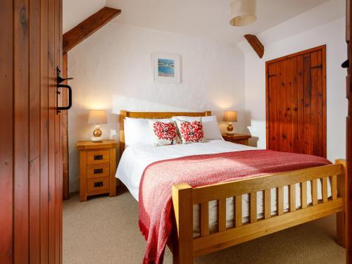 a bedroom with a bed with a red blanket at Pond Meadow in Launceston