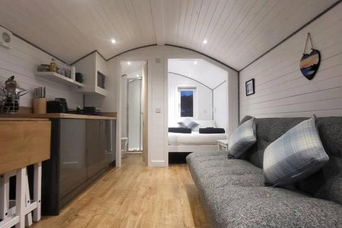 a living room with a couch and a kitchen at Loch Shiel Luxury Pod in Acharacle