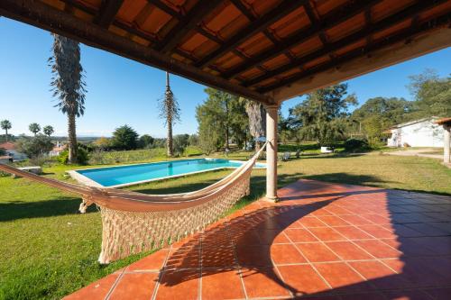 a hammock on a patio next to a swimming pool at Fantástica Casa de Campo com Piscina perto de Lisboa in Santarém