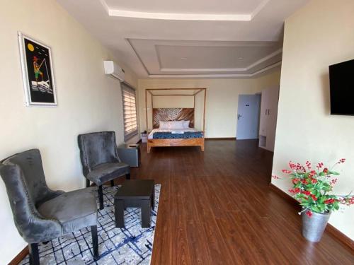 uma sala com um quarto com uma cama e cadeiras em Oceanfront Wavecrest Hotel em Lekki