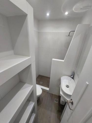 a white bathroom with a toilet and a sink at Yaque Suite in El Yaque