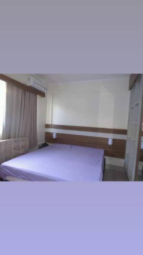 a bed in a small room with at Lacqua Diroma apartamento barato in Caldas Novas