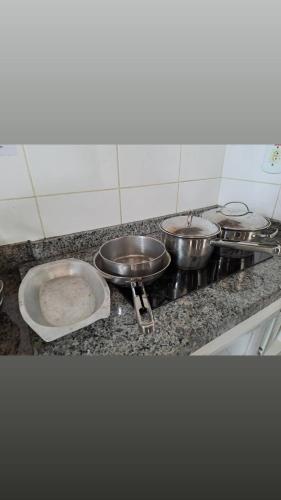 a kitchen with three pots and pans on a counter at Lacqua Diroma apartamento barato in Caldas Novas