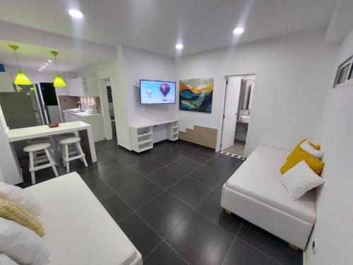 a living room with a white couch and a tv at Yaque Suite in El Yaque