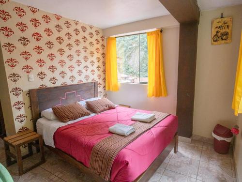 a bedroom with a large bed with a pink blanket at ECO ART Best view Machu Picchu in Machu Picchu