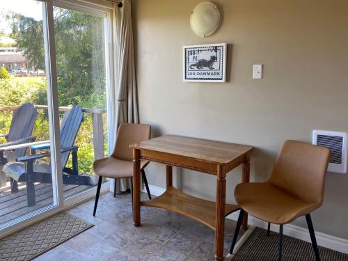 a table and chairs in a room with a balcony at Wheeler on the Bay Lodge and Marina in Wheeler