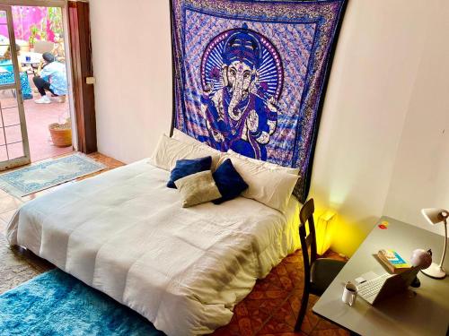 a bedroom with a bed with a tapestry on the wall at Free Spirit Hostel Guadalajara in Guadalajara