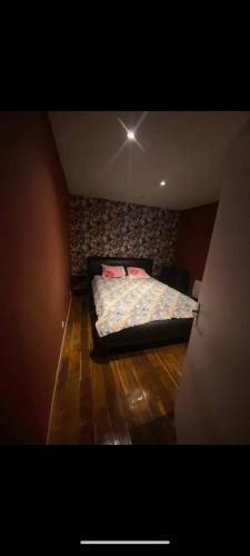 - une chambre avec un lit dans un dortoir doté de parquet dans l'établissement Maisonette de plain pied à 5 à pied de la gare de denain., à Denain