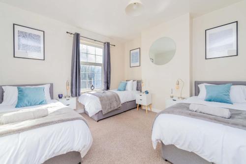 une chambre avec deux lits et une fenêtre dans l'établissement Central Townhouse Wolverhampton - Sleeps 8 - Ideal for Contractors & Families, à Wolverhampton