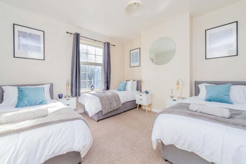 a bedroom with two beds and a window at Central Townhouse Wolverhampton - Sleeps 8 - Ideal for Contractors & Families in Wolverhampton