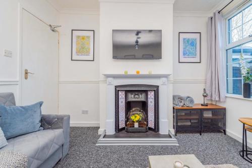 a living room with a fireplace and a couch at Central Townhouse Wolverhampton - Sleeps 8 - Ideal for Contractors & Families in Wolverhampton