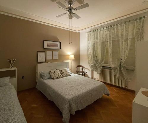 een slaapkamer met een bed en een plafondventilator bij Casa San Marco in Lucca