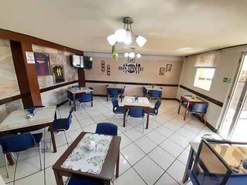 ein Esszimmer mit Tischen und Stühlen in einem Restaurant in der Unterkunft Hotel y Restaurante Villa Esmeralda in Quetzaltenango