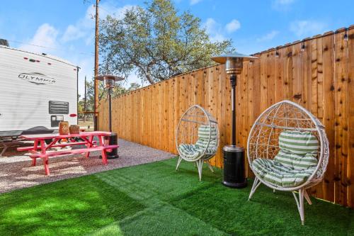 a backyard with two chairs and a table and a fence at Park access! Bars & Restaurants close-by! Private in Austin