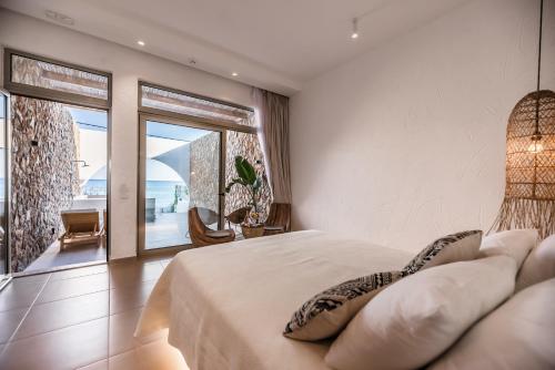 アルハンゲロスにあるDelfini Beach Hotel & Suitesの海の見えるベッドのある寝室