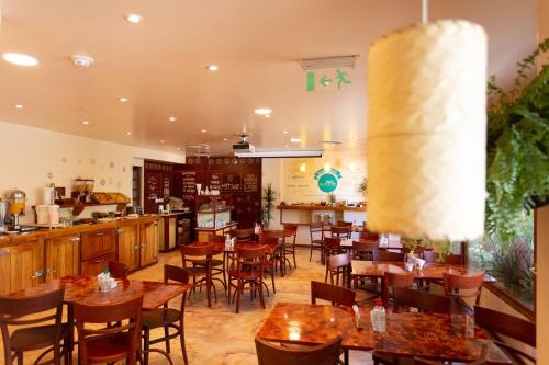 a restaurant with wooden tables and chairs and a counter at Hotel Suizo in Neuquén