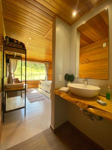 a bathroom with a sink and a bunk bed at Chalé do Lago Urupema SC in Urupema