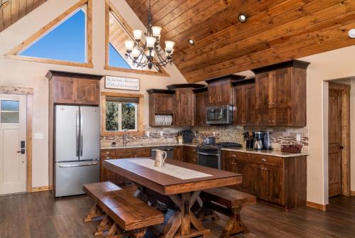 cocina con armarios de madera y mesa de madera en Skyfall Cabin. Stunning views, Hot Tub, minutes from Zion, en Orderville