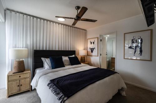 a bedroom with a bed and a ceiling fan at Rolling Surf Resort in Caloundra