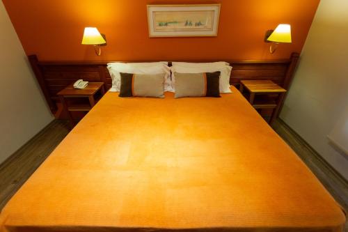 a bedroom with a large bed with two night stands at Hotel Suizo in Neuquén