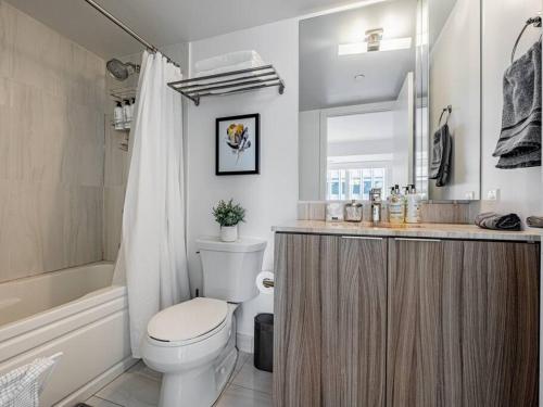 a bathroom with a toilet and a sink and a mirror at Luxury Condo on Bay Street in Toronto