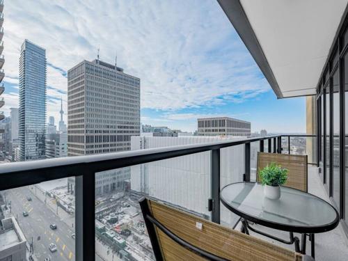 a balcony with a table and chairs and a view of a city at Luxury Condo on Bay Street in Toronto