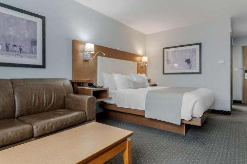 a hotel room with a bed and a couch at Best Western Plus Woodstock Hotel Conference Centre in Woodstock