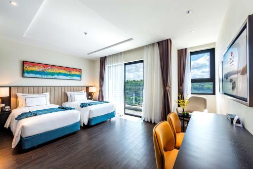 a hotel room with two beds and a table and chairs at Best Western Premier Sapphire Ha Long in Ha Long