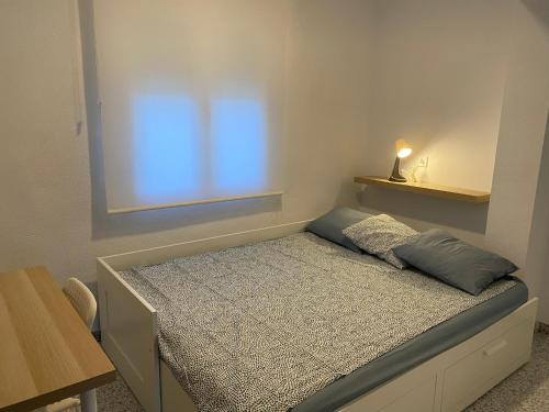 Dormitorio pequeño con cama y ventana en Casa Jesùs, en Ontinyent