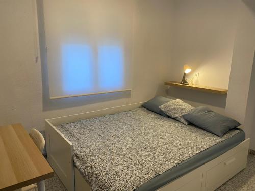 a small bedroom with a bed with a window at Casa Jesùs in Ontinyent