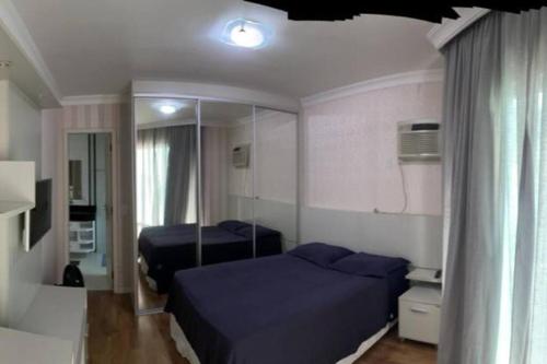 1 dormitorio con 2 camas y espejo en Linda casa com piscina, en Balneário Camboriú