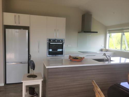 a kitchen with a white refrigerator and a sink at Shearer's Quarters in Rotorua