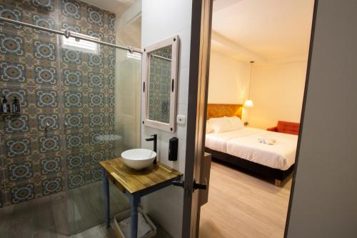 a bathroom with a shower and a bedroom with a bed at Hotel Pajara Pinta in Cali