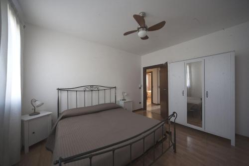 een slaapkamer met een bed en een plafondventilator bij La Pioppa Agriturismo in Sacile