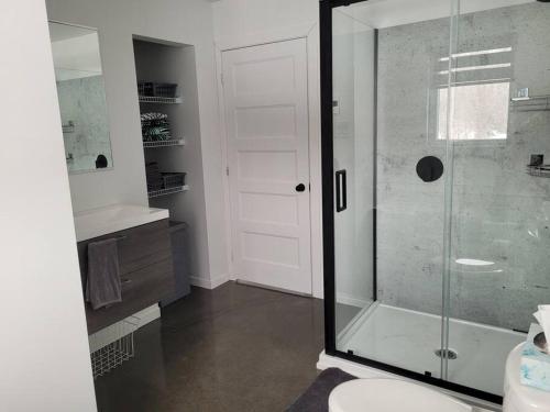 La salle de bains est pourvue d'une douche en verre et de toilettes. dans l'établissement Chalet Elizée & Spa, à Saint-Ferdinand