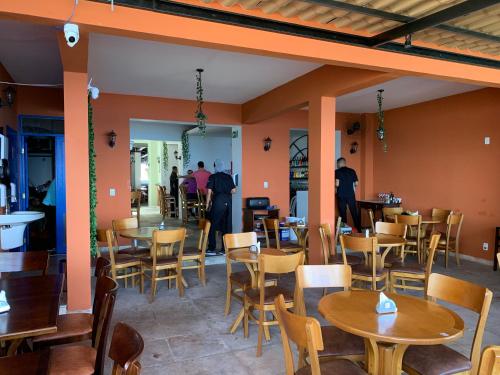 um restaurante com mesas e cadeiras e pessoas ao fundo em Hotel Villa Salvador em Salvador