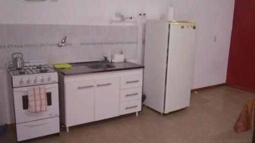 eine Küche mit einem weißen Kühlschrank und einer Spüle in der Unterkunft Mi Lugar in Olavarría